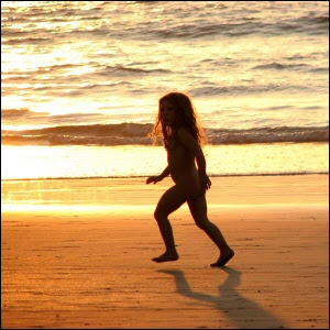 Western girl child running naked on the beach in Gokarn, India