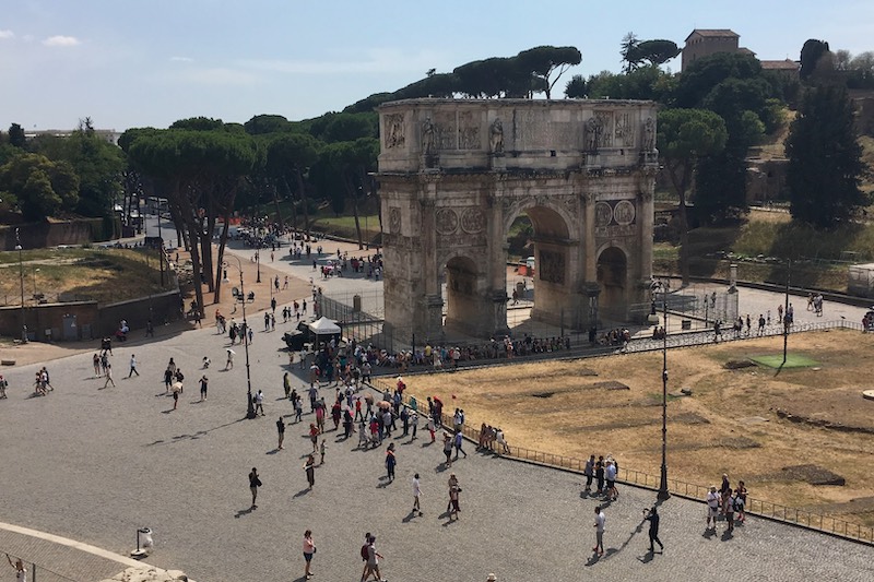 Arch of Constantine in Rome, Italy, surrounded by tourists on a sunny day